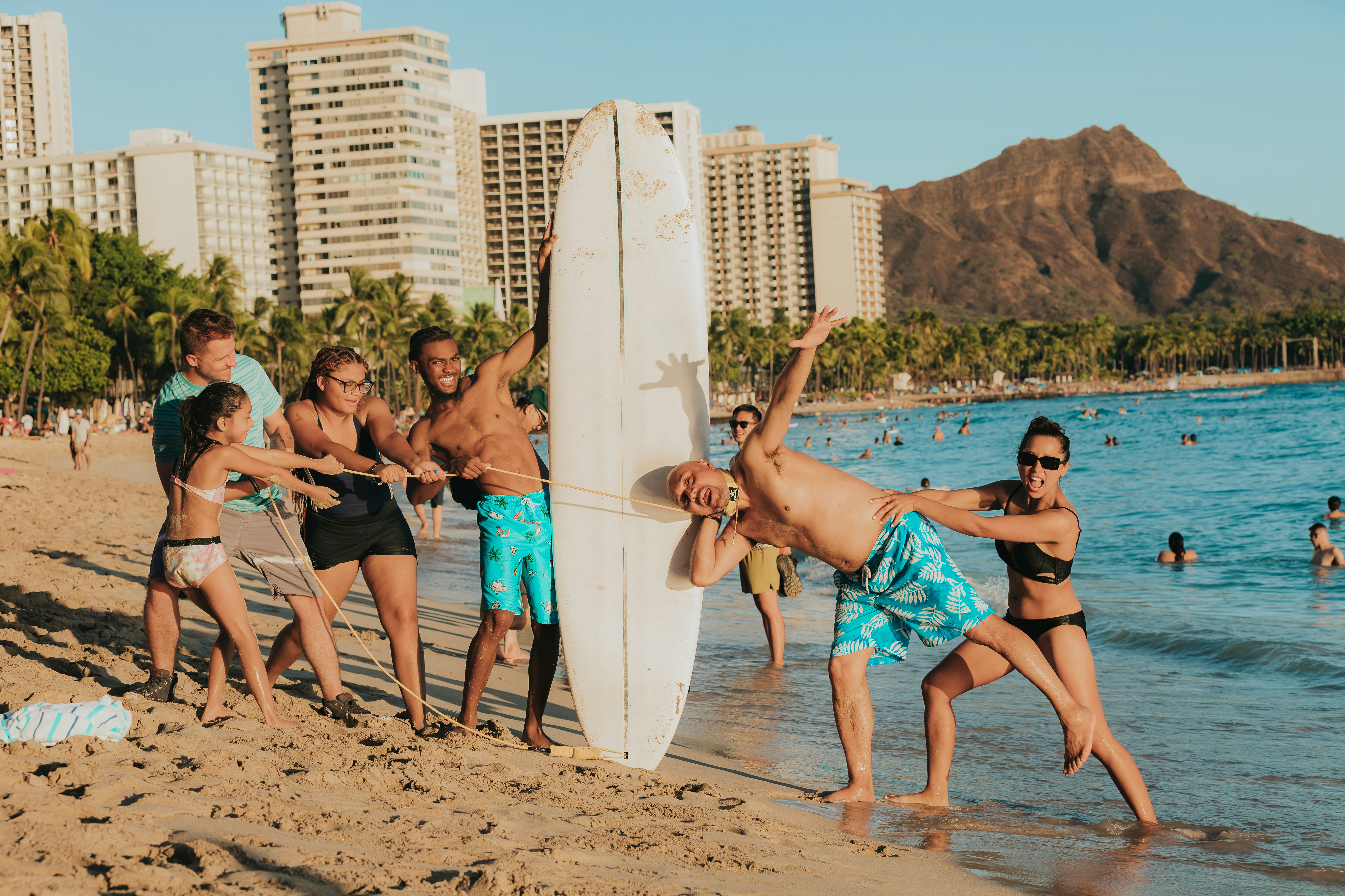 Family enjoying a surf lesson together on a sunny Kauaʻi beach