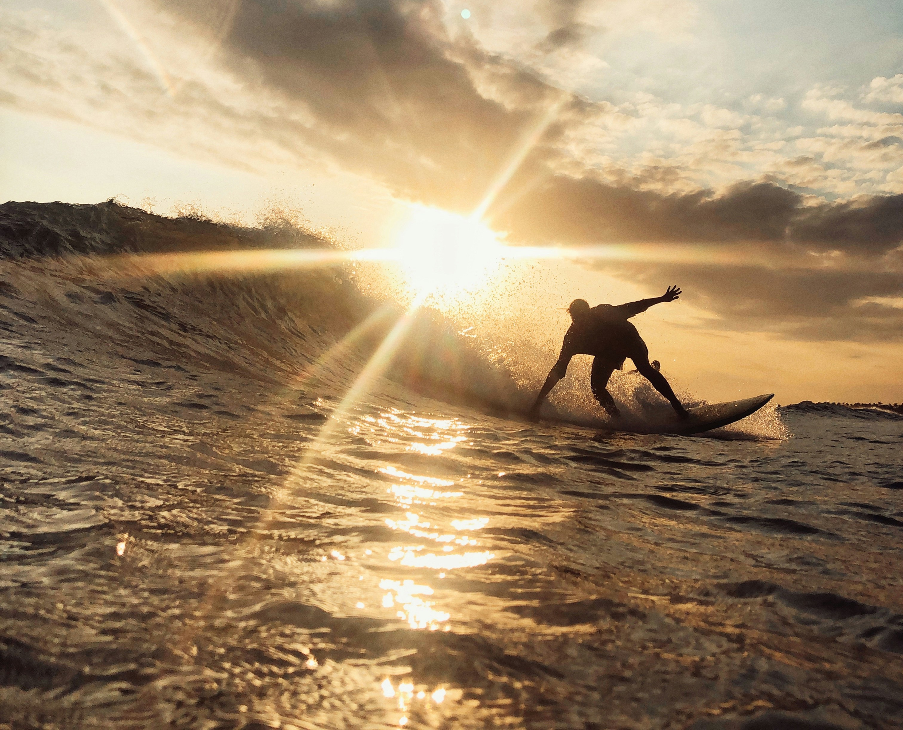 Happy surfers relaxing on their boards at golden hour